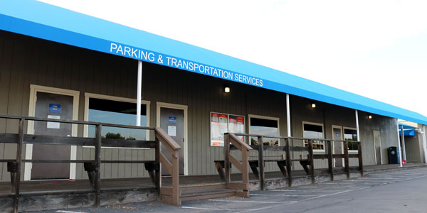 photo of the outside of the parking office, blue awning